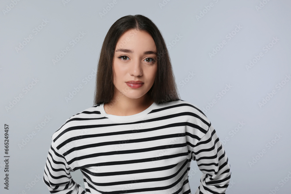 Portrait of beautiful young woman on light grey background Portrait of beautiful young woman on light grey background