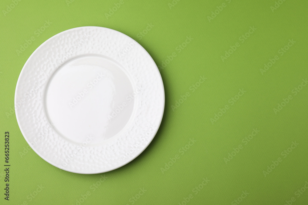 One clean plate on green background, top view. Space for text One clean plate on green background, top view. Space for text