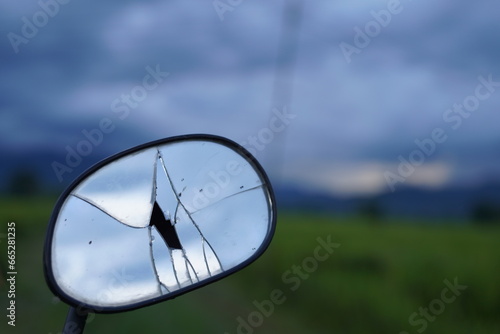 Broken motorcycle side mirror Beautiful rice field background on the mountain On the background of green mountains beautiful blue sky