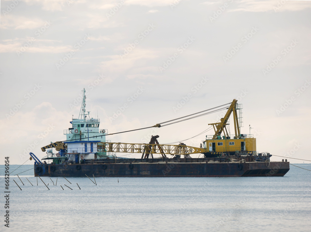 a large floating dredging excavator on sea coast