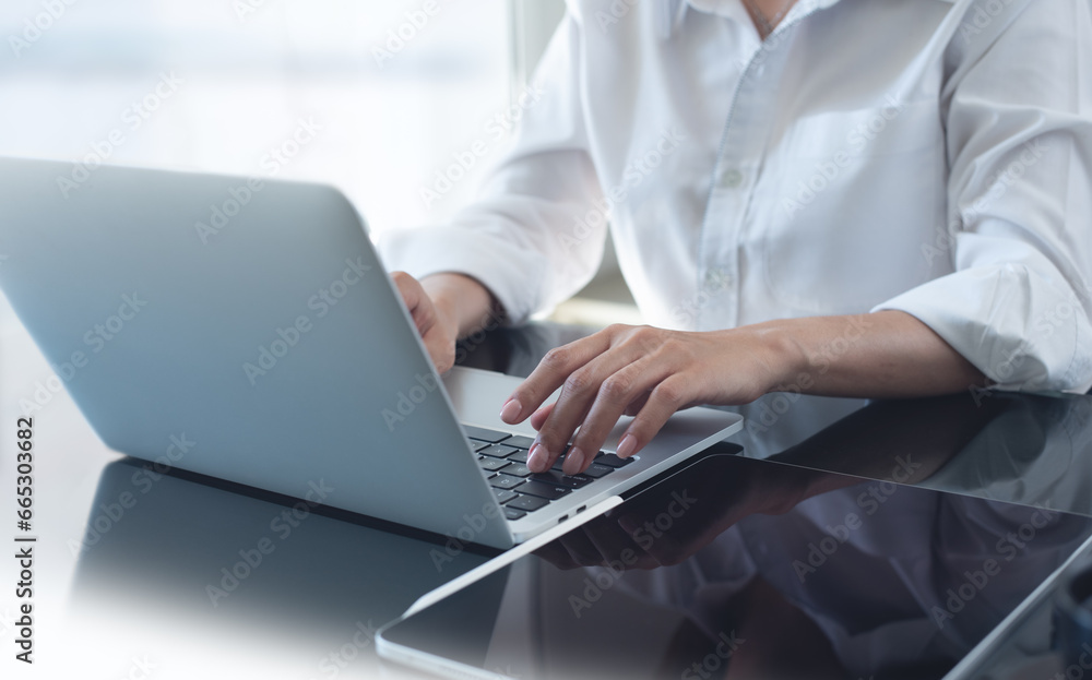 Businesswoman working on laptop computer at modern office. Business woman hands typing on laptop computer keyboard, searching business data, surfing the internet with digital tablet on office table, Businesswoman working on laptop computer at modern office. Business woman hands typing on laptop computer keyboard, searching business data, surfing the internet with digital tablet on office table,