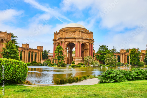 Palace of Fine Arts across lagoon water with cloudy blue sky overhead