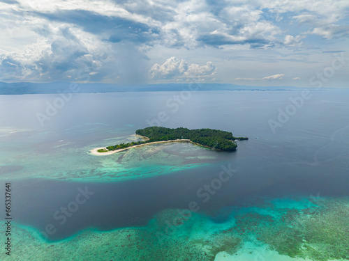 Cabgan Islet with white sandy beach, blue sky and clouds. Barobo, Surigao del Sur. Philippines.