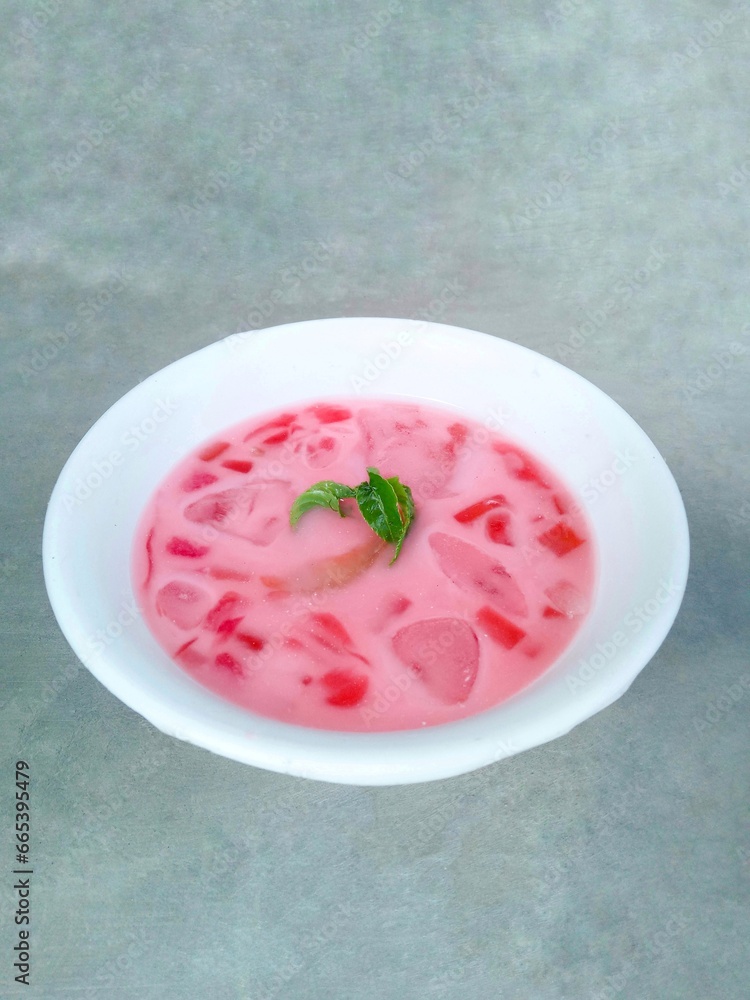 fruit soup and jelly served in bowls. pink soup. watermelon and melon ice on gray background. fresh and delicious. Vertical shot fruit soup and jelly served in bowls. pink soup. watermelon and melon ice on gray background. fresh and delicious. Vertical shot