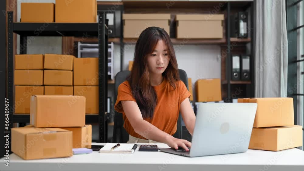 Young Asian business owner woman prepare parcel box and standing check online orders for deliver to customer on tablet, laptop Shopping Online concept. Young Asian business owner woman prepare parcel box and standing check online orders for deliver to customer on tablet, laptop Shopping Online concept.