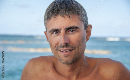 Portrait of a happy caucasian man relaxing on a beautiful beach