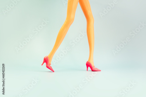Doll legs on blue background copy space.