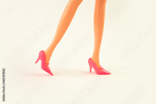 Plastic doll legs in toy shoes on white background. educational games for children.