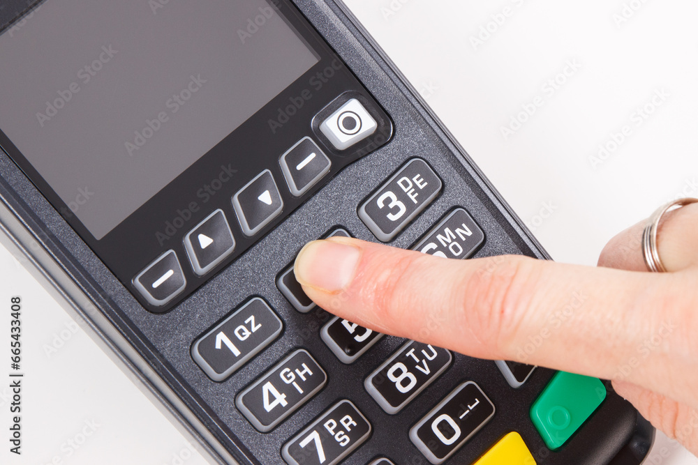 Hand of woman using credit card reader to enter PIN code. Cashless paying. Finance and banking Hand of woman using credit card reader to enter PIN code. Cashless paying. Finance and banking