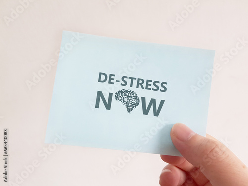 Fotografie Stress Awareness. Holding a note with the words De-Stress Now