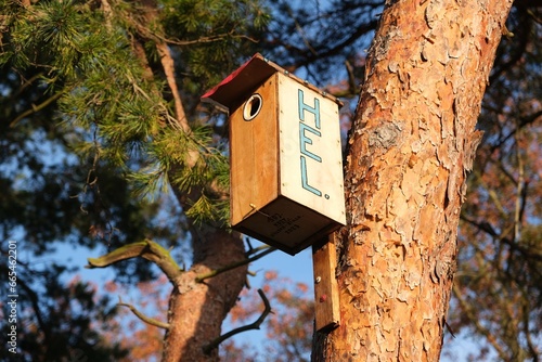 A wooden birdhouse on a tree with the name of the town of Hel. Pomerania, Hel Penisula