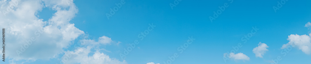 Blue sky and white clouds float in the sky on a clear day with warm sunlight. The sky was clear in the calm sunshine. Bright winter weather background.