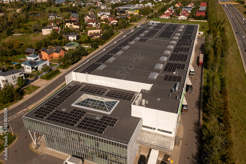 Drone photography of large logistical warehouse and office rooftop with solar energy modules © M