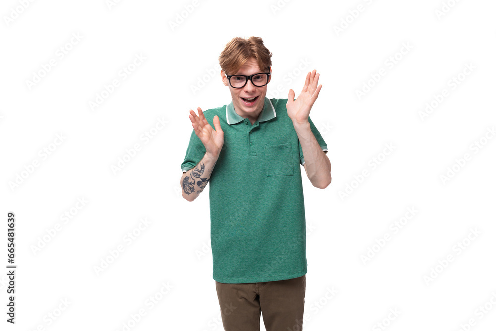 young surprised caucasian man with red hair dressed in a green t-shirt shrugs his shoulders in ignorance young surprised caucasian man with red hair dressed in a green t-shirt shrugs his shoulders in ignorance
