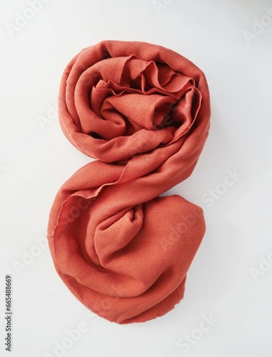 orange spirall rolled rag on white table. spirall folded in the shape. rolled fabric tissue. crumpled rag swirl photo