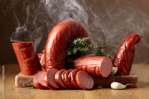 Smoked sausage with thyme and garlic on a wooden table.