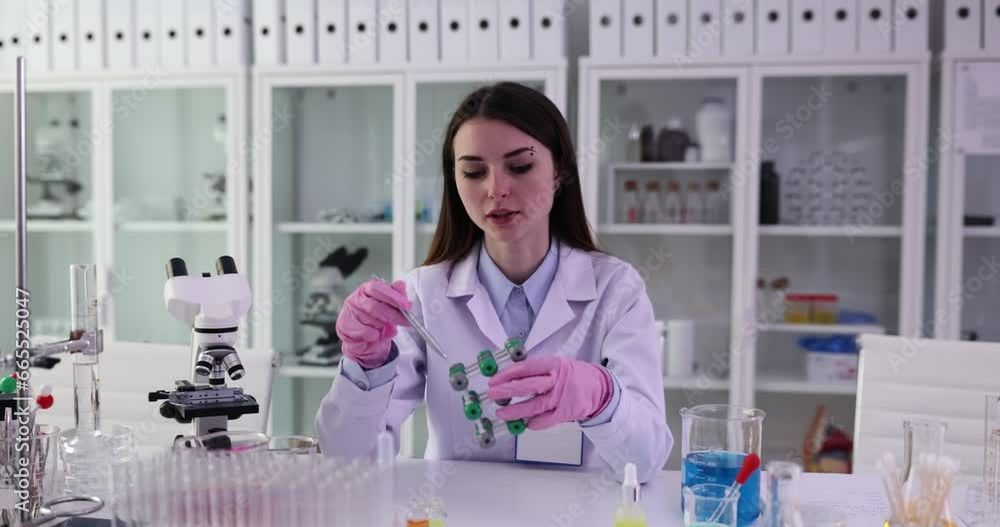 Female scientist or student holding molecular structure model in lab. Concept of science education and chemical research Female scientist or student holding molecular structure model in lab. Concept of science education and chemical research