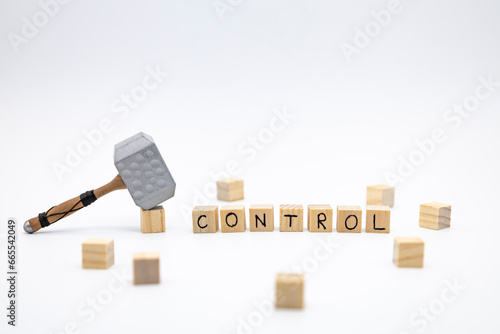 The wooden cubes with the word CONTROL and the weapon around against white background. The medieval hammer on a wooden cube. photo