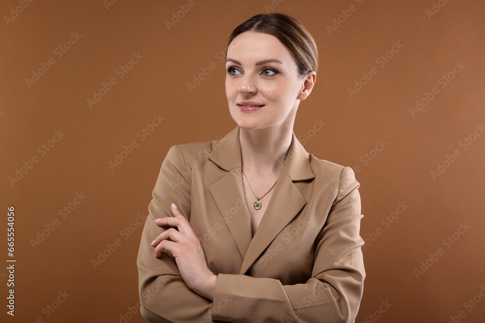 Beautiful woman with elegant necklace on brown background Beautiful woman with elegant necklace on brown background