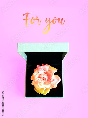 Creative layout made of colorful rose in jewelry box on pastel pink background. Minimal spring concept. Creative spring idea. Flat lay. Copy space. Mock up. Romantic present. Woman's day. For you.
