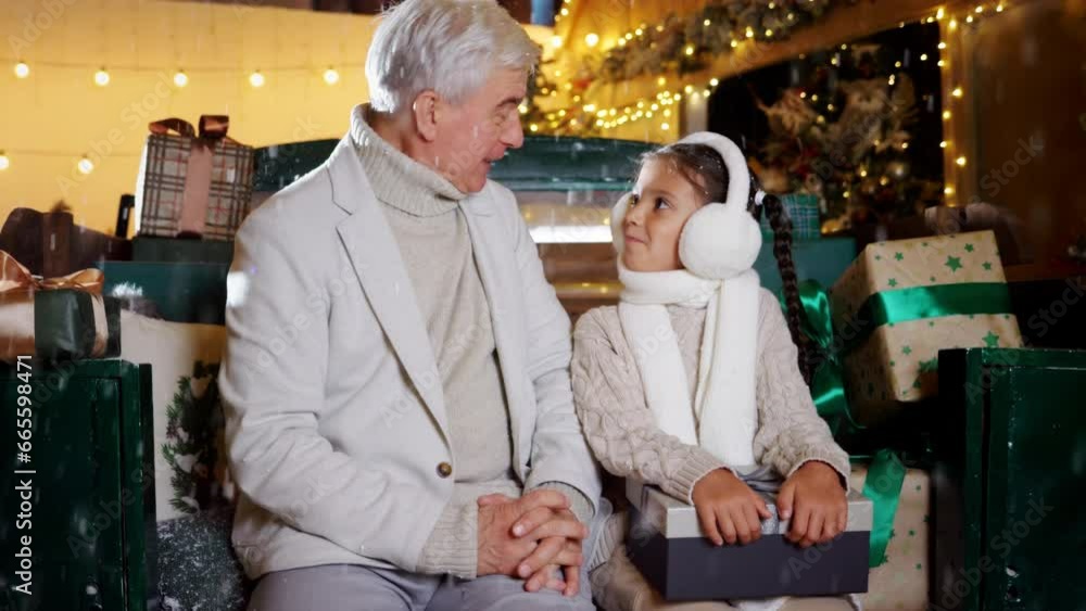 Christmas night time of happy old grandfather and child granddaughter talking winter holidays under magical snow. Family New Year dream and lovely festive weekend Christmas night time of happy old grandfather and child granddaughter talking winter holidays under magical snow. Family New Year dream and lovely festive weekend
