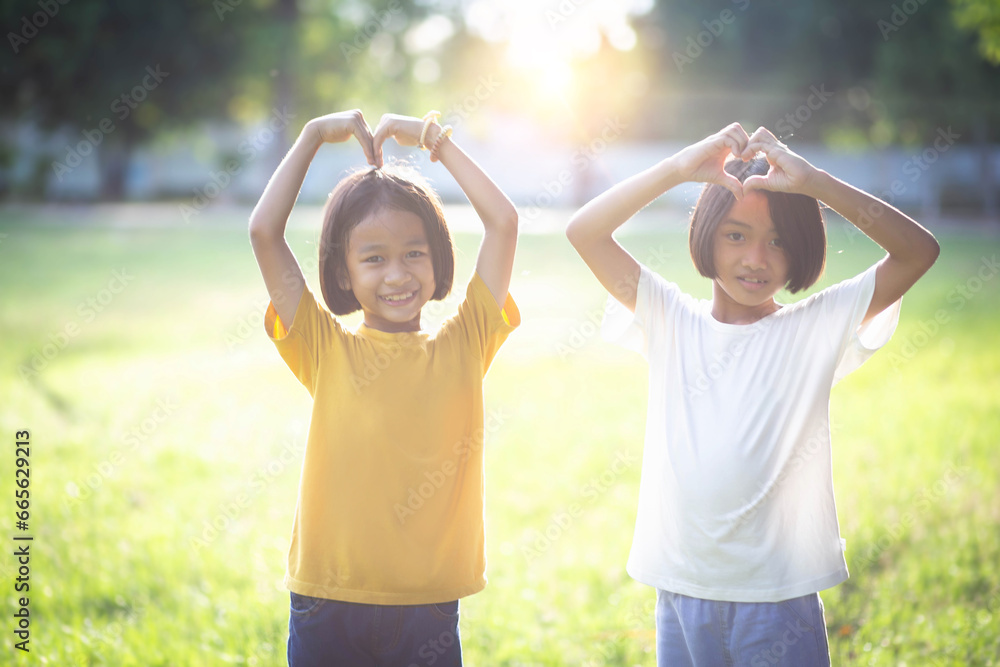 Obraz premium Adorable little siblings play happily on the green grass.