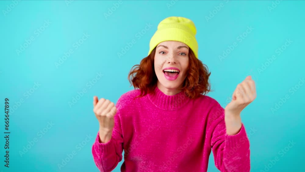 Yes approval gesture and winner woman smiling, say Yes. Excited happy young lady, pink sweater, showing approving thumbs up, for victory, deal, success. Satisfied emotion, studio on blue, stop motion Yes approval gesture and winner woman smiling, say Yes. Excited happy young lady, pink sweater, showing approving thumbs up, for victory, deal, success. Satisfied emotion, studio on blue, stop motion