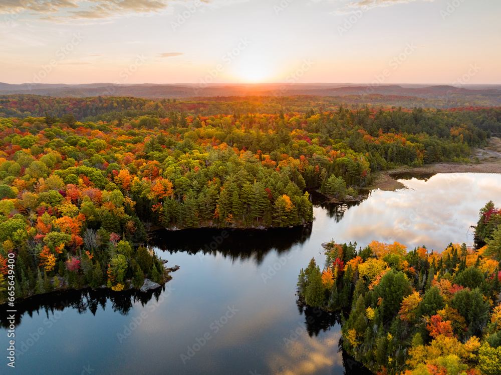 High angle view of a sunrise over a narrow lake and forest in autumn High angle view of a sunrise over a narrow lake and forest in autumn