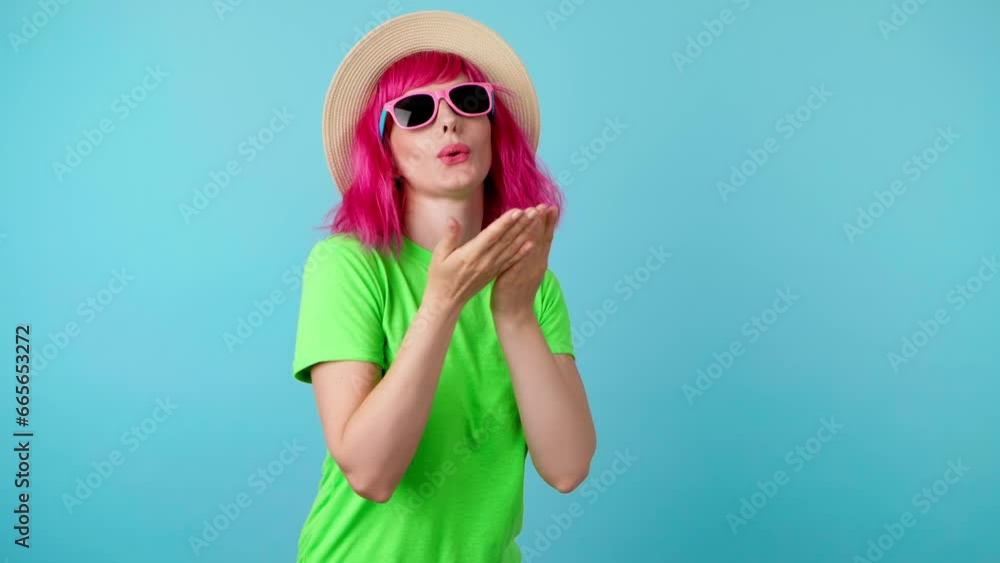 Wink, flirt and hipster woman, pink hair, sending air kiss and happy excited smiling. Fashionable lady blowing a kiss with confidence flirty emotion for cosmetics makeup, trendy outfit on blue Wink, flirt and hipster woman, pink hair, sending air kiss and happy excited smiling. Fashionable lady blowing a kiss with confidence flirty emotion for cosmetics makeup, trendy outfit on blue