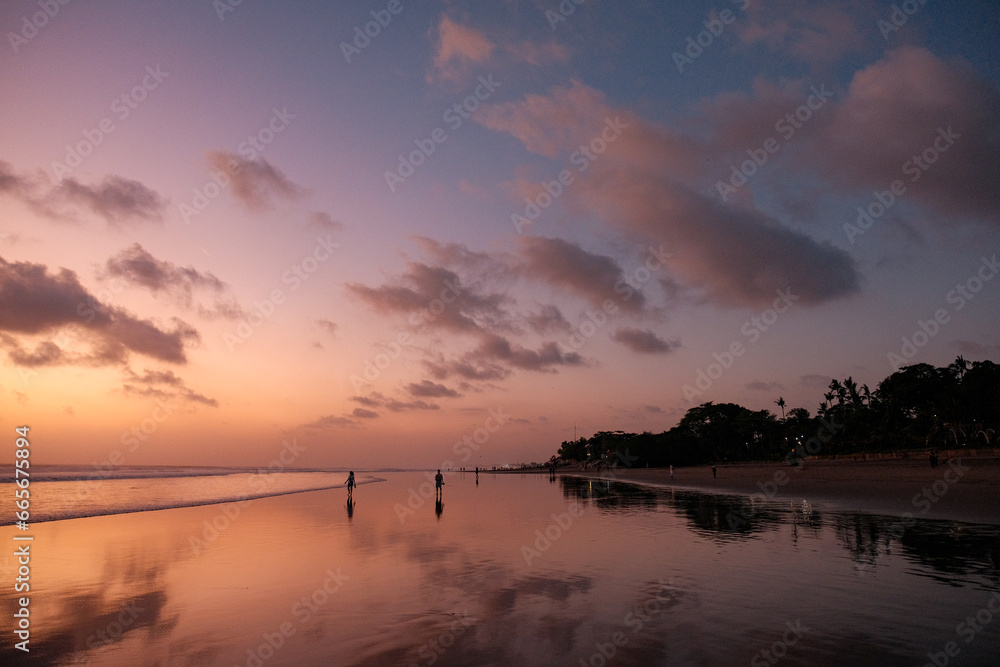Beachgoers Embrace the Orange Sunset, Where Gentle Waters Are