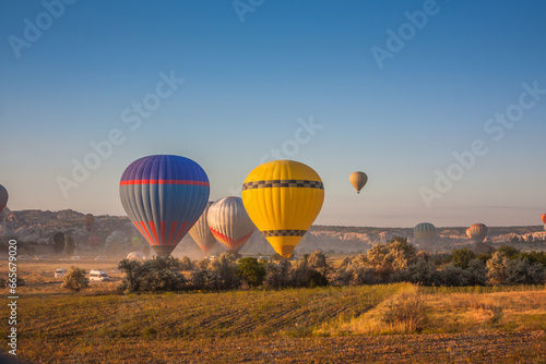 Hot air balloons take off from the ground early in the morning. Hot air balloons flying over bizarre rock landscape in Cappadocia. Beautiful hot air balloons in the morning sky. Goreme. Turkey © decorator