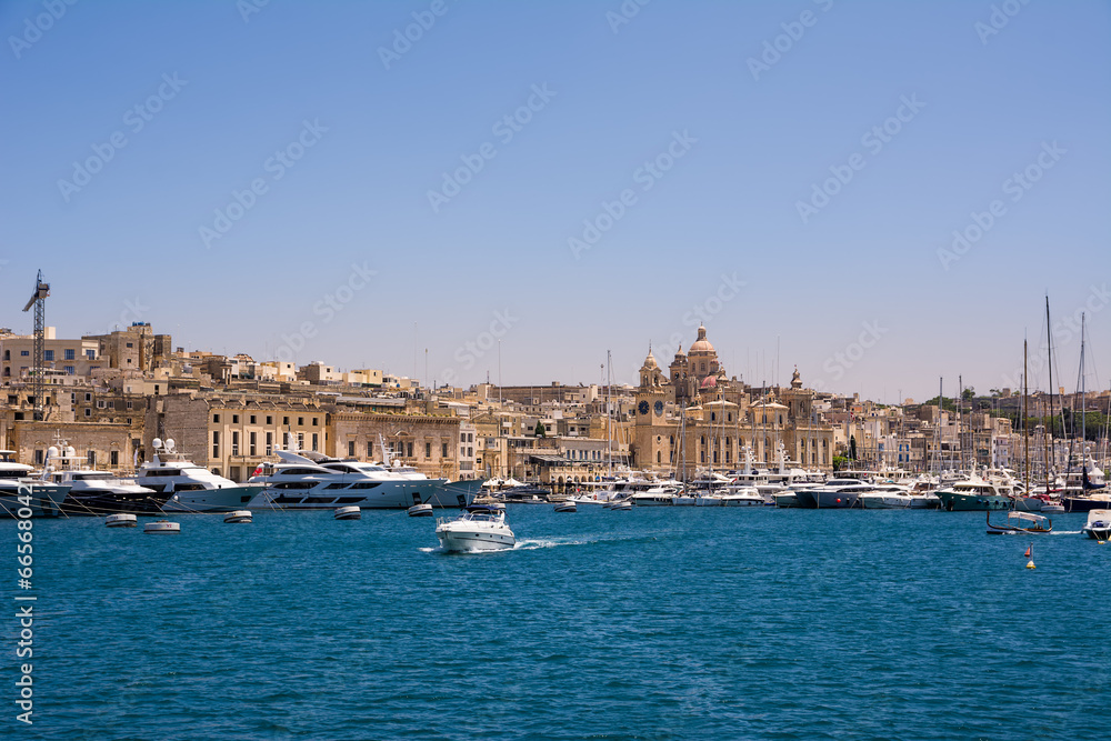 Vittoriosa harbor with yachts and boats and the dome of the cathedral in the background