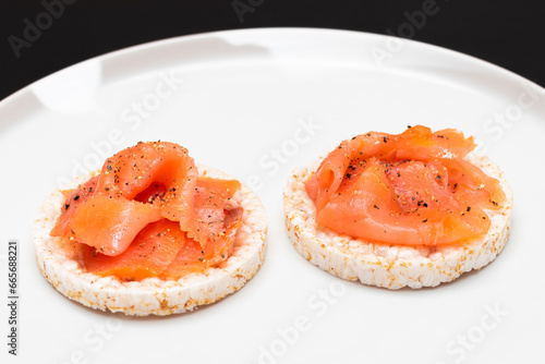 Tasty Rice Cake Sandwiches with Fresh Salmon Slices on White Plate. Easy Breakfast and Diet Food. Crispbread with Red Fish. Healthy Dietary Snack