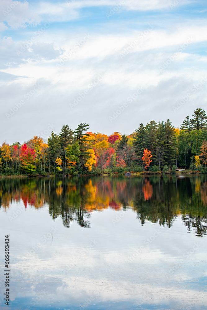 Obraz premium Colorful autumn trees on lake of the Falls in Mercer, Wisconsin