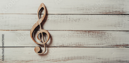 simbolo musicale chiave di violino, di sol realizzata in legno su superficie in legno bianca photo