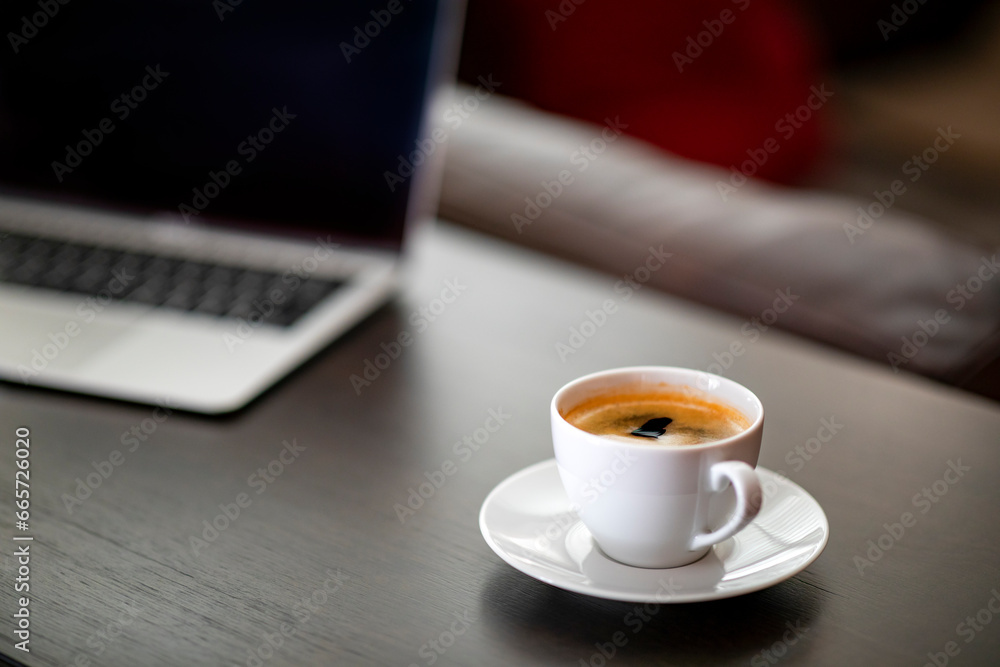 cup of coffee and laptop on wooden table cup of coffee and laptop on wooden table