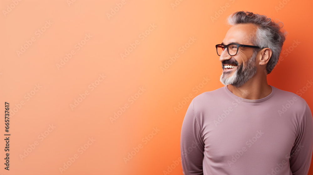 An older gentleman grinning while standing against a backdrop with space for text or images.. An older gentleman grinning while standing against a backdrop with space for text or images..
