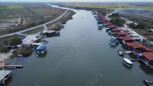 Aerial flyover Fisherman Cabins at Axios Delta National Park, Greece during cloudy day photo