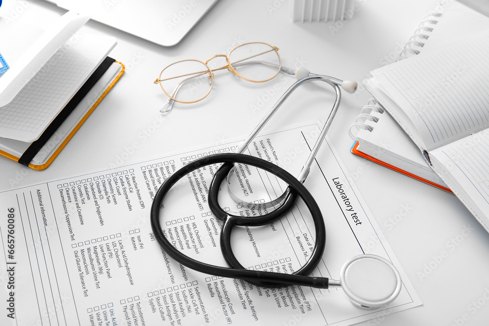 Stethoscope with laboratory test and notebooks on white medical desk, closeup Stethoscope with laboratory test and notebooks on white medical desk, closeup