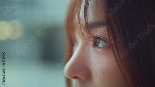 Close up - Young asian woman opens his black eyes on a blurred background photo
