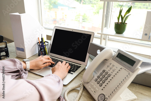 Woman using laptop at table...