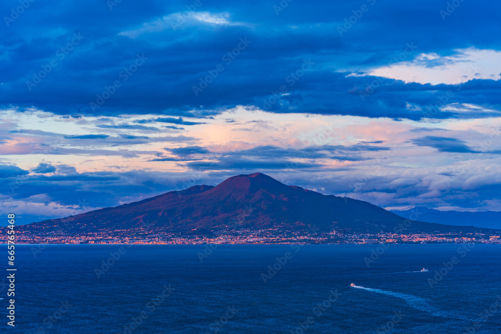 View of Mount Vesuvius across the Bay of Naples in Italy at dusk