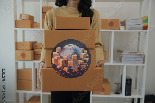 Mujer de negocios exitosa preparando sus envíos a todo el mundo. Lleva sus paquetes para etiquetar. Icono del mundo y envíos nacionales e internacionales. Estantes con mercadería en el fondo. photo
