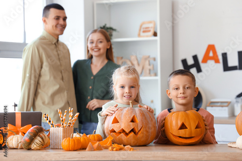 Little children with carved Halloween pumpkins in kitchen photo