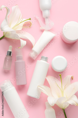 Composition with different cosmetic products and lily flowers on pink background