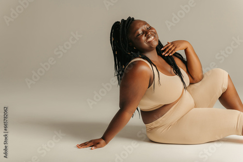 Joyful plus curvy African woman in sportswear radiating self-love  photo