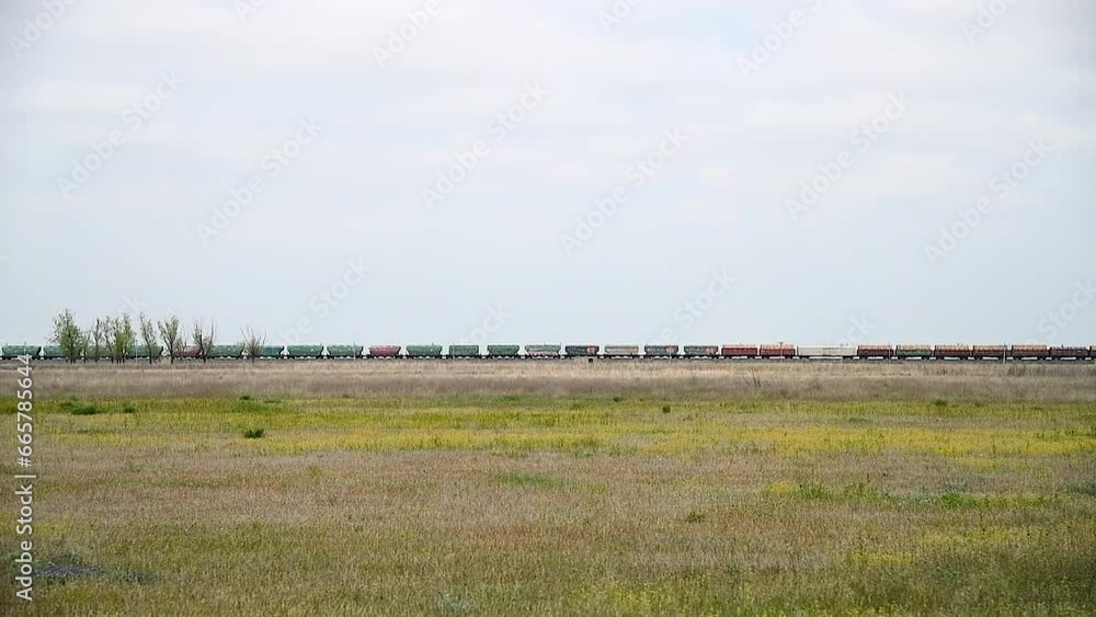 Locomotive pulls a very large and heavy freight train with wagons and tank cars along a railway Locomotive pulls a very large and heavy freight train with wagons and tank cars along a railway