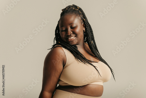 Attractive African plus size woman in underwear radiating self-love on studio background