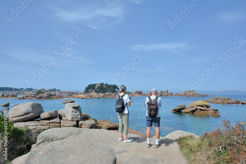 Des personnes qui observent un très beau paysage de mer sur la côte de granit rose en Bretagne - France