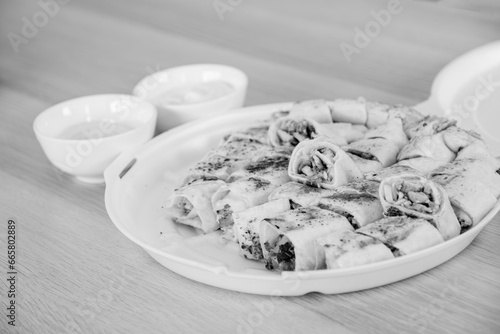 Black and white shawarma plate with dips